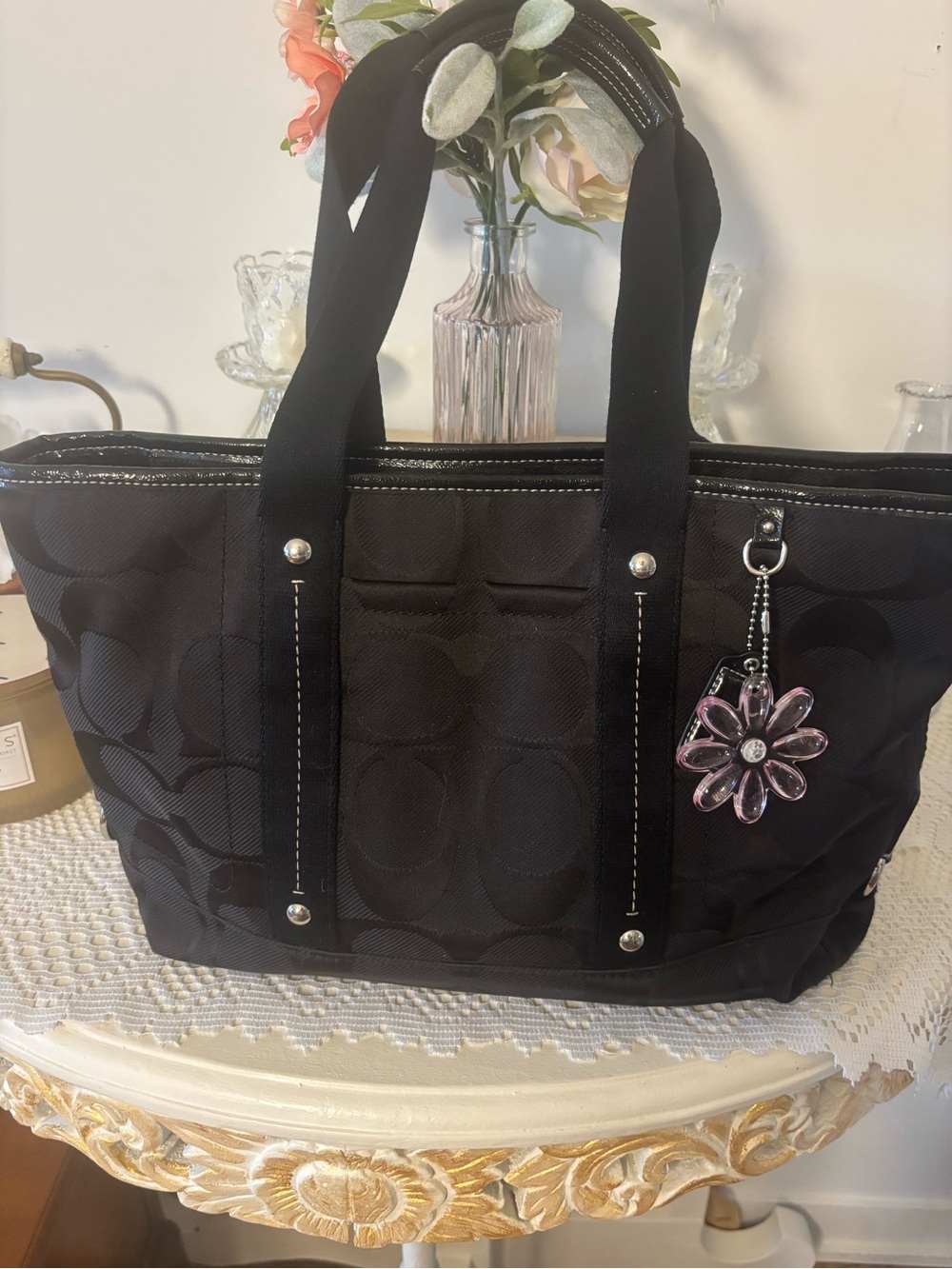 Coach Kyra Signature Daisy Tote with pink flower charm and tag.
